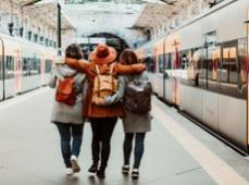 Tres chicas de espalda en el andén del tren