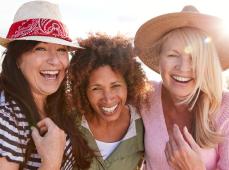 Tres mujeres abrazadas sonriendo
