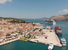 Chica sonriendo con gafas y sobrero de paja por una histórica calle
