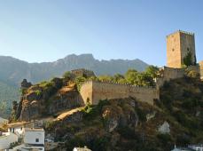 Castillo en lo alto de un cerro y casas blancas en su ladera