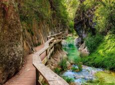 Camino de madera en la ladera de la montaña y un rio al otro lado
