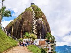 Peñon lleno de vegetación donde se aprecian escaleras que suben hasta la cima