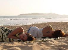 dos personas de espaldas manejando un kayak en el agua