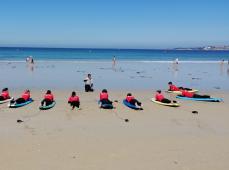 Chicos tumbados en tablas en la playa