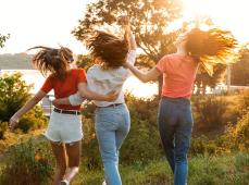 tres chicas de espaldas andando por el monte