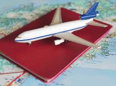 avión en miniatura encima de un pasaporte y un mapa