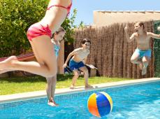 Niños tarándose al agua en una piscina