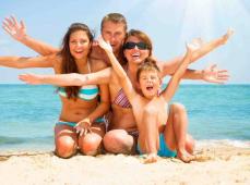 Familia posando en la  playa con los brazos en alto