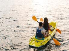Niña montada en un kayax en el mar