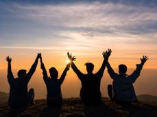 Jóvenes de espaldas mirando al atardecer