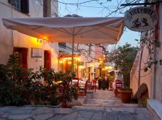 Calle al atardecer con terrazas y mesas para comer