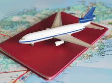 mapa mundi de papel y encima un pasaporte y un avión en miniatura