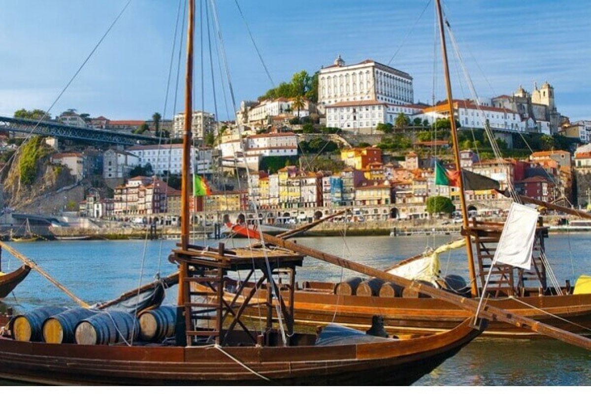 Embarcaciones típicas en el río, al fondo vista panorámica de Oporto y al lado izquierdo el famoso puente Luis I