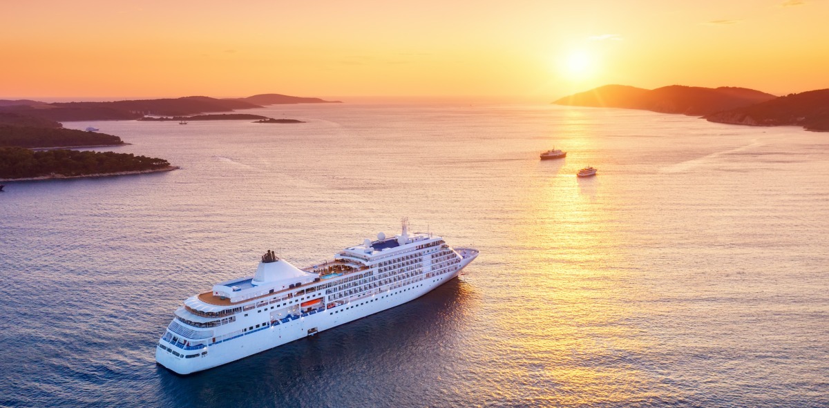 Crucero navegando entre islas al atardecer