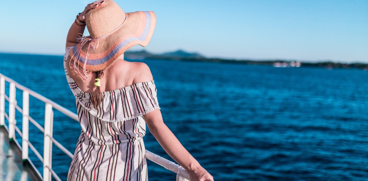 Mujer single viendo el horizonte desde la cubierta del barco