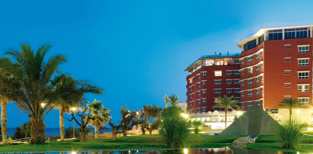 Panorámica de un hotel con palmeras y césped
