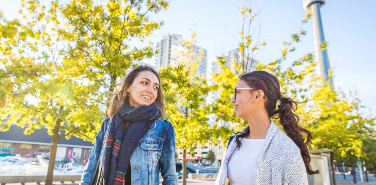 Dos mujeres sonrientes paseando por la ciudad