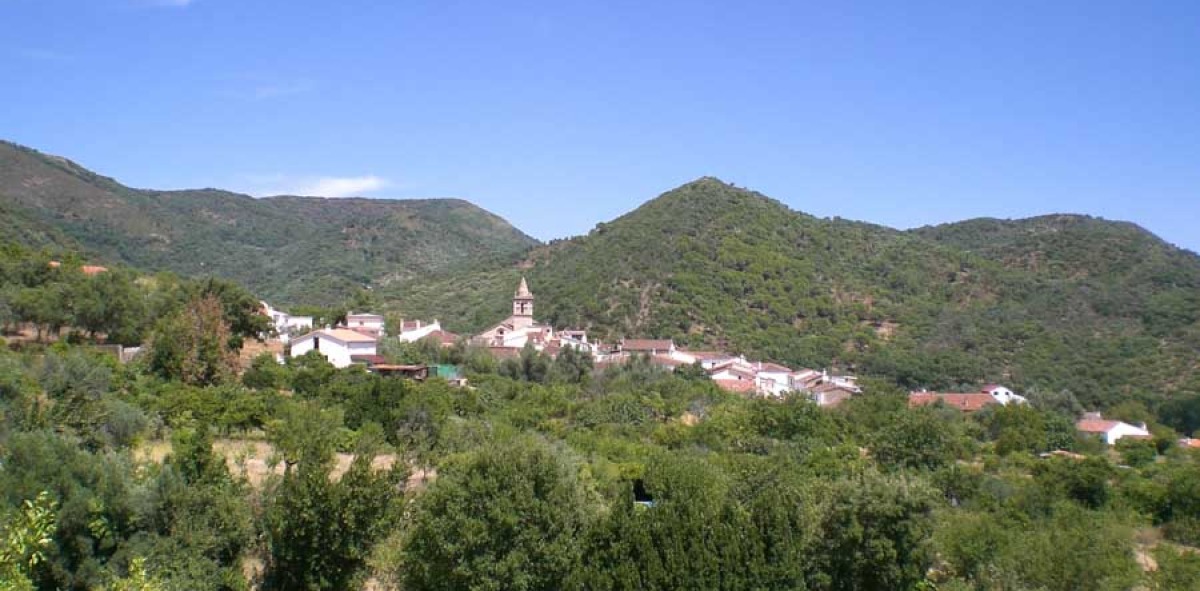 Pueblo situado en las verdes montañas con casas blancas y un campanario