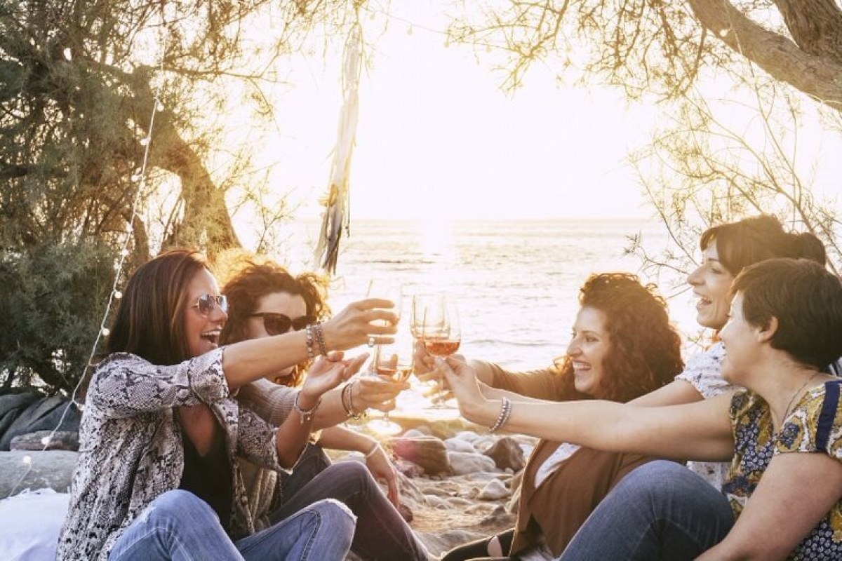Grupo de chicas brindando en la playa