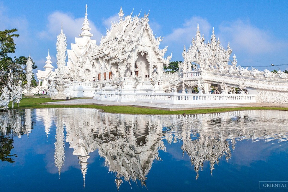 Un lago y a su orilla un templo todo de color blanco al que se llega por un puente también blanco
