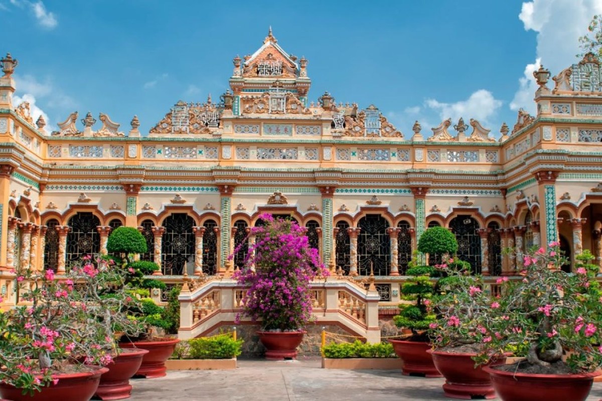 Vistas de un palacio de colores rodeado de plantas de colores rosas