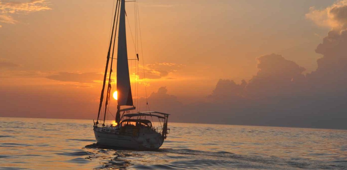 Velero navegando en un atardecer