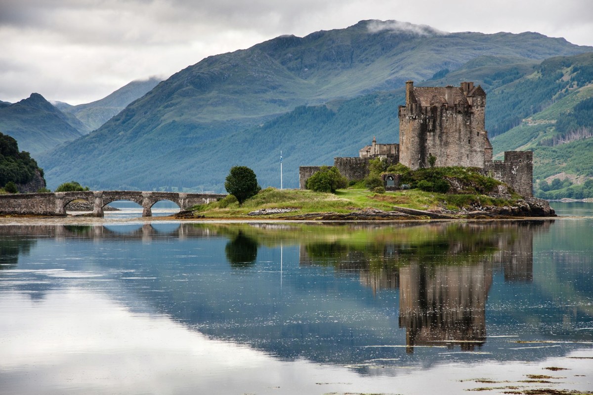 Espectacular castillo antiguo situado en el medio de un lago al que entras por un puente de tres ojos rodeado de altas montañas