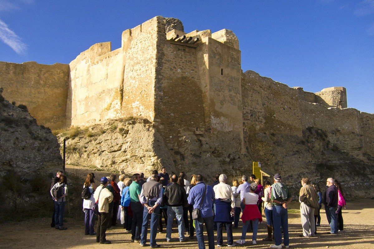 Foto grupal atendiendo las explicaciones del guía en el Castillo Mayor