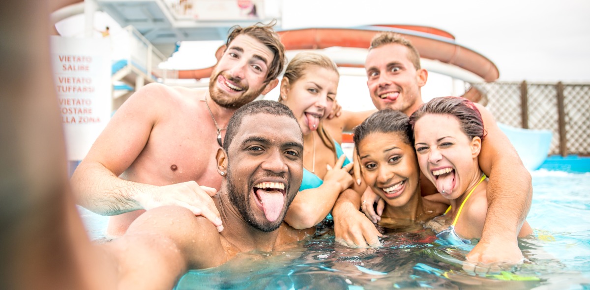 Amigos singles divirtiéndose en la piscina del crucero