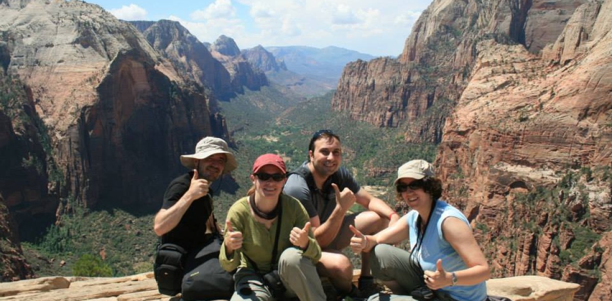 Solteros Viajeros en la cima de una montaña, al fondo un cañón