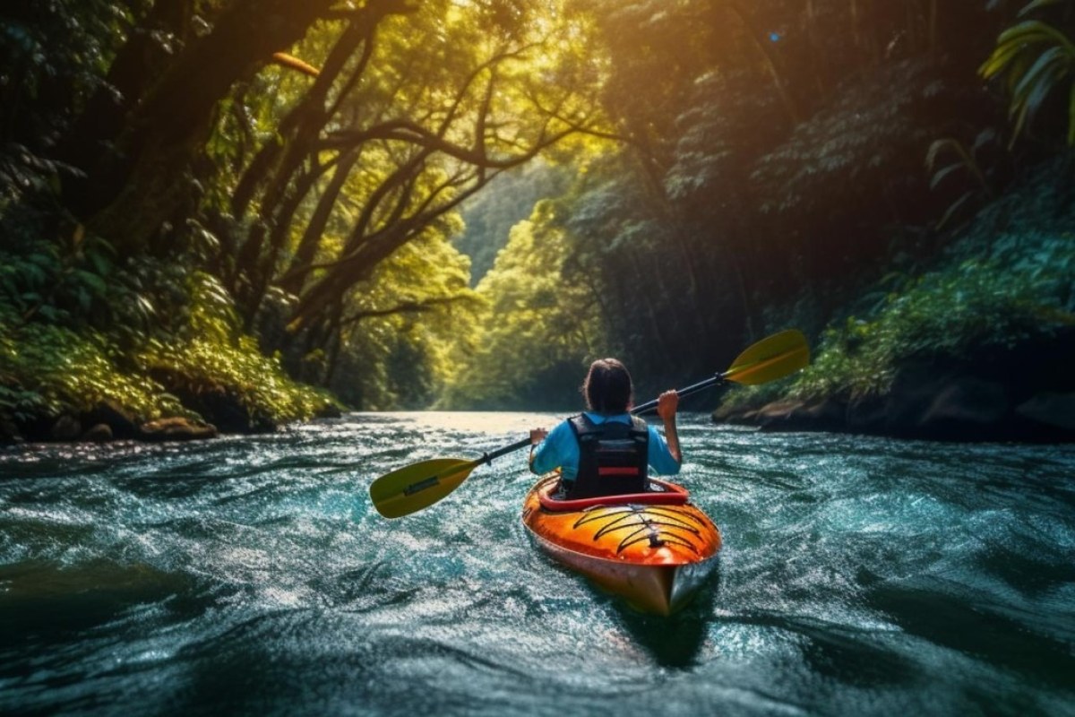 Niño montado en un kayak en un río rodeado de vegetación
