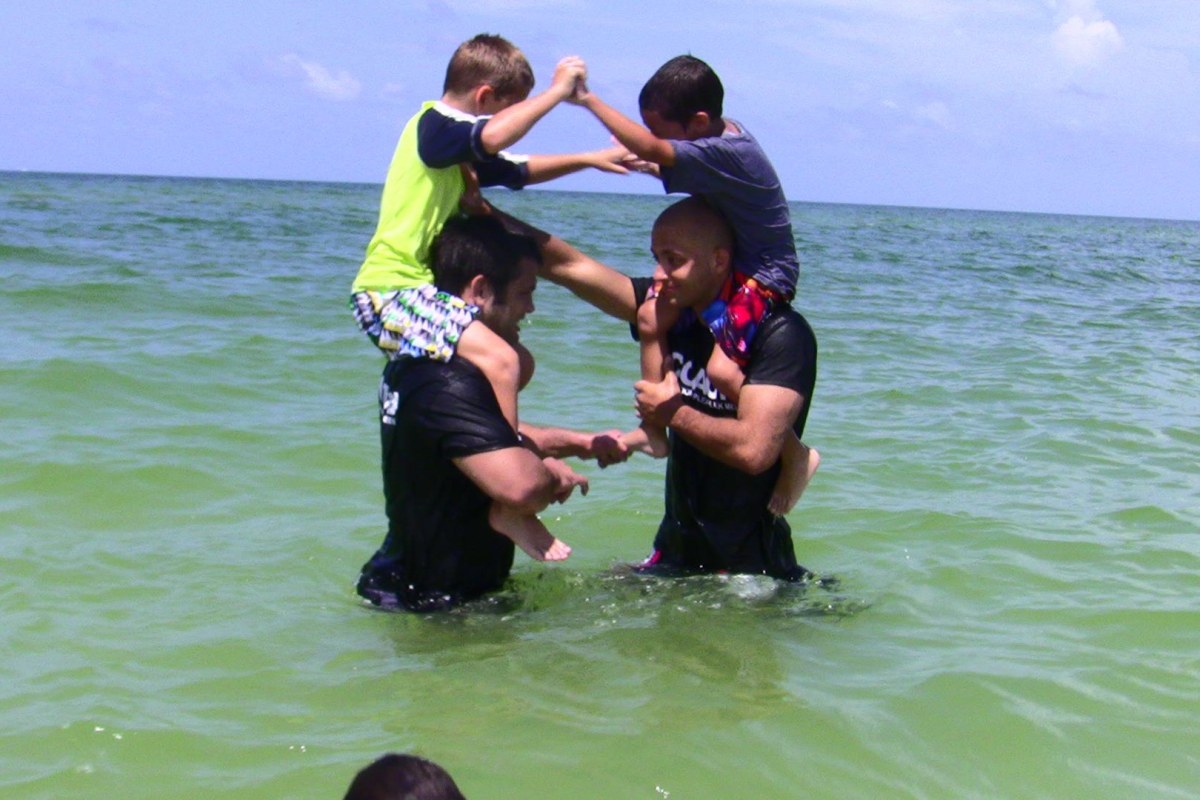 Padres con sus niños jugando en la playa
