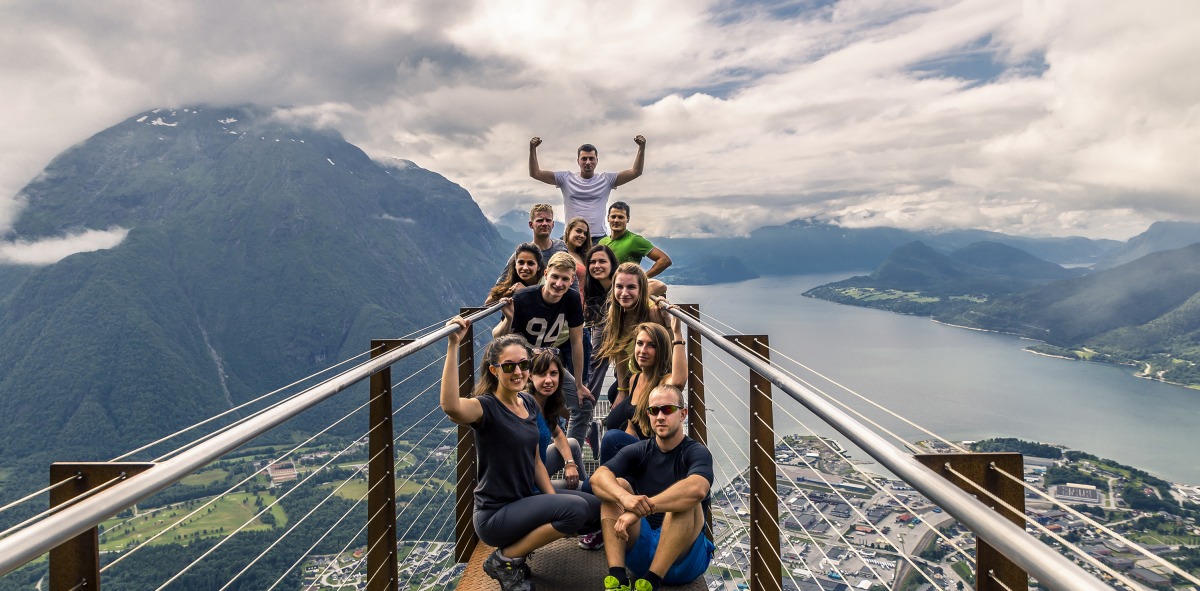 Posando de Solteros viajeros en un mirador suspendido en el aire donde se ve abajo una ciudad