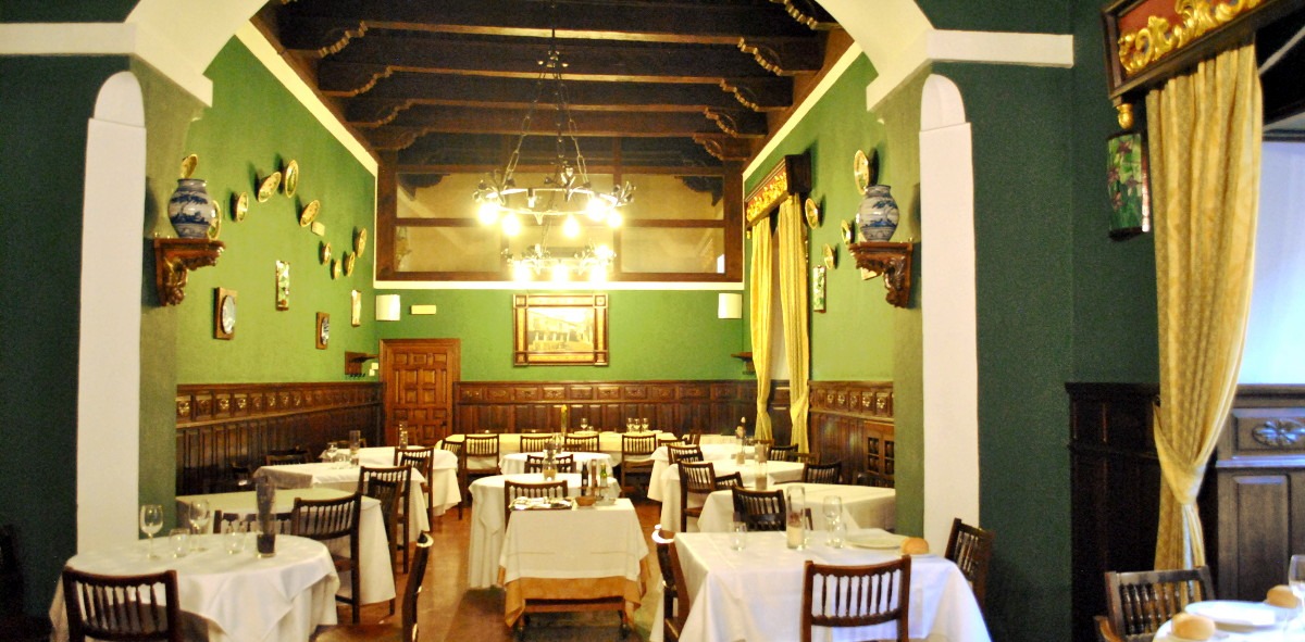 Comedor típico con mesas de madera y paredes forradas en madera