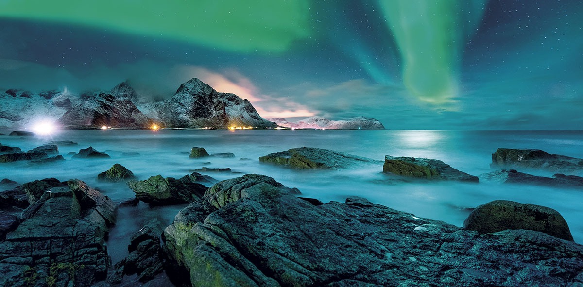 Impresionante paisaje nevado y en el cielo una Aurora Boreal