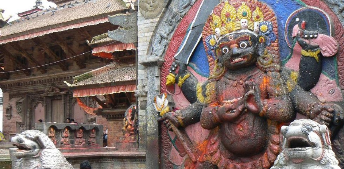 Templo budista donde aparece en piedra una figura de color negra con coronas de colores