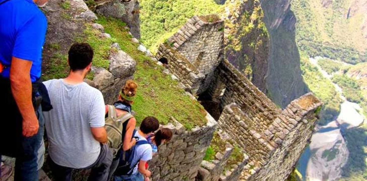 Grupo de Solteros Viajeros bajando por unas escaleras antiguas empinadas, al fondo el valle