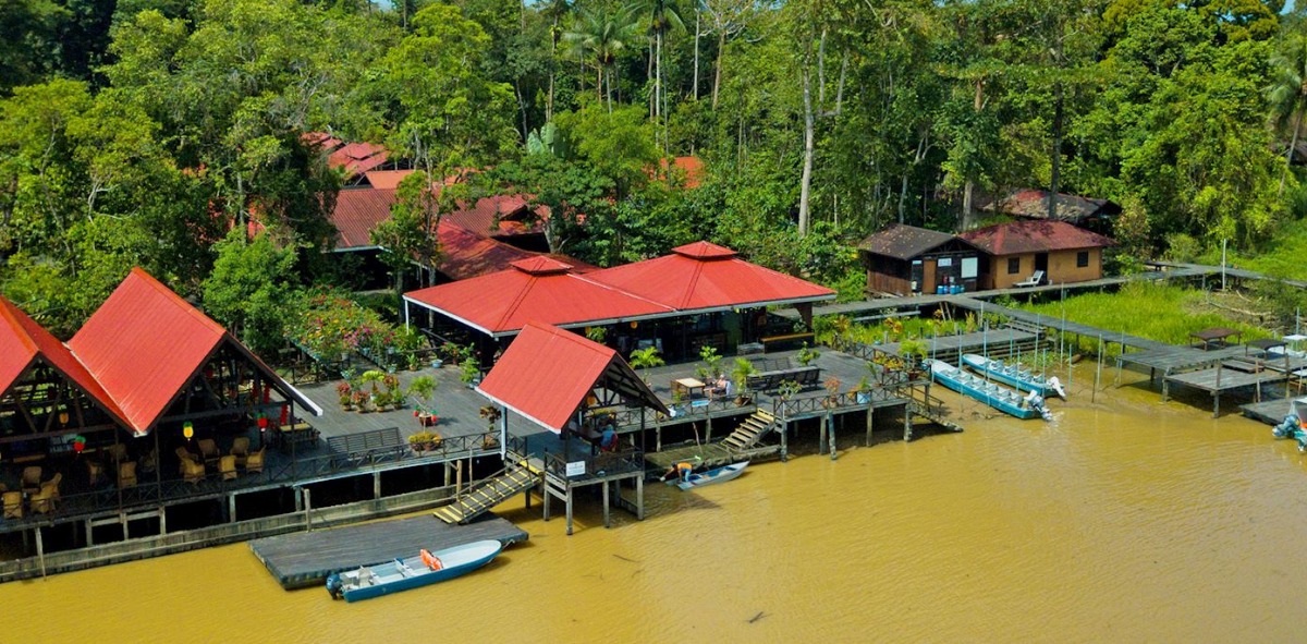 Hotel en la selva en casas de madera de techo rojo al lado del rio