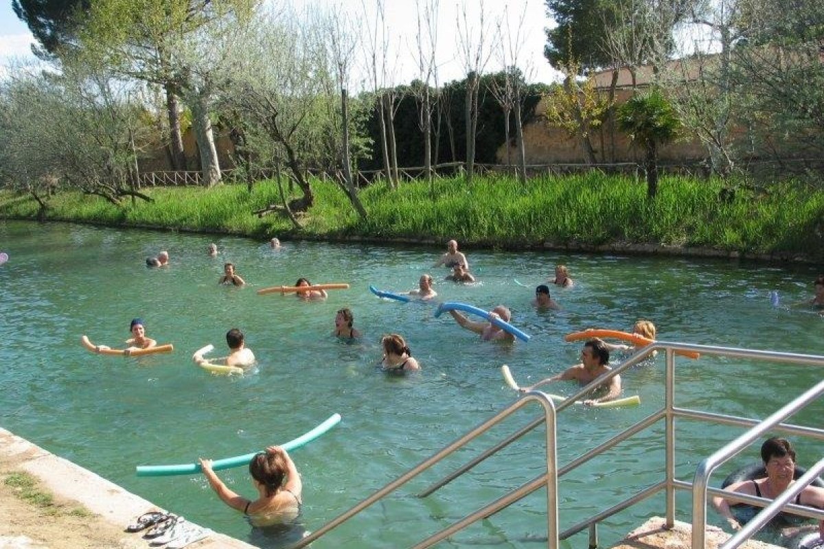 Grupo de mayores y niños en el río haciendo agua gym