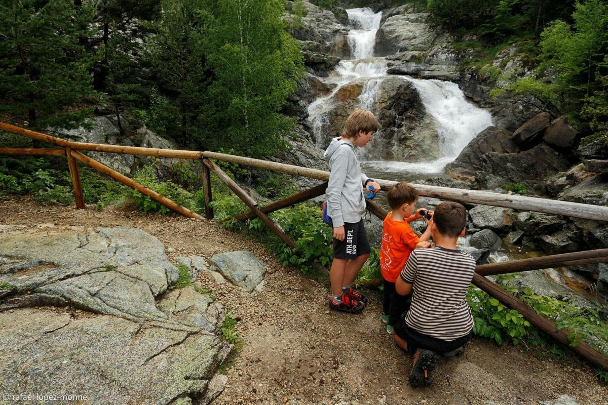 Niños asomados viendo la caída de una cascada