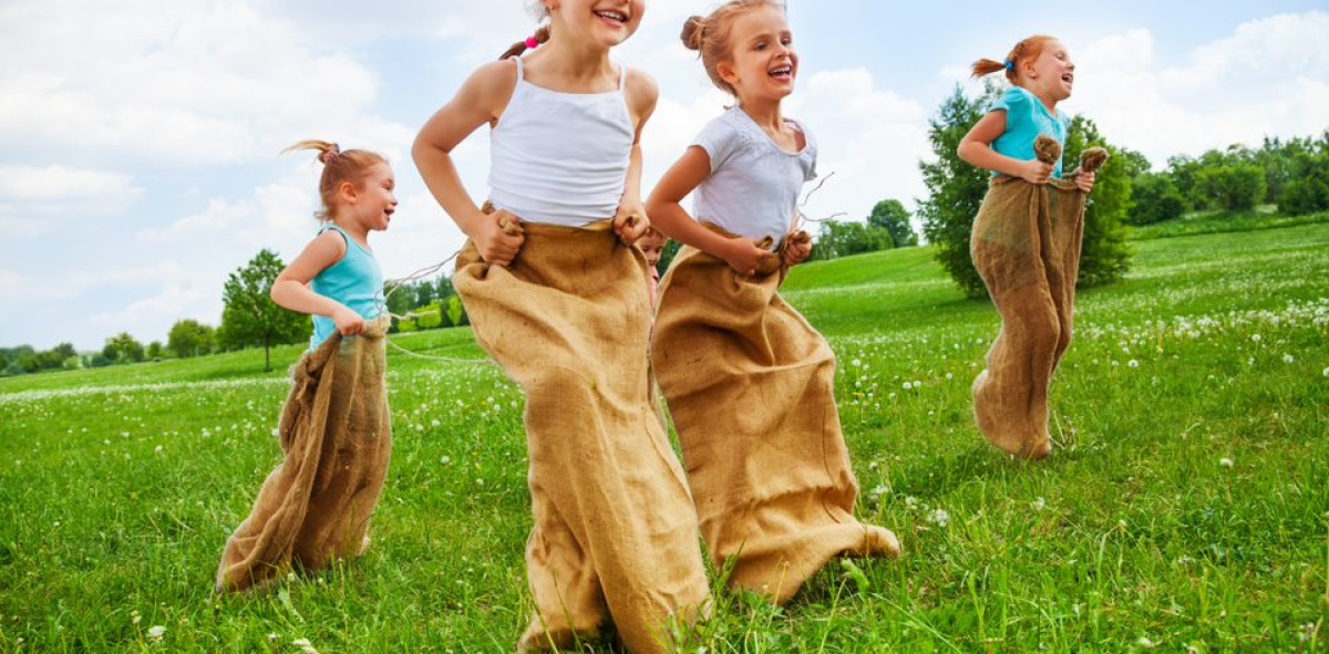 Cuatro niñas jugando a la carrera de sacos