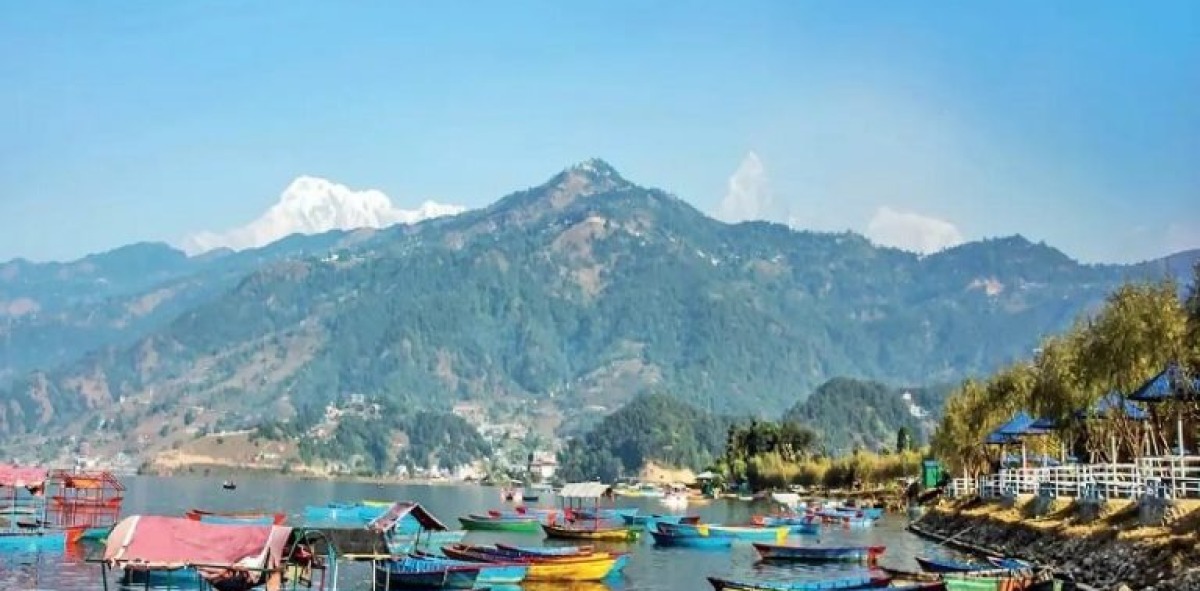 Lago repleto de barquitas de colores y al fondo pico montañoso