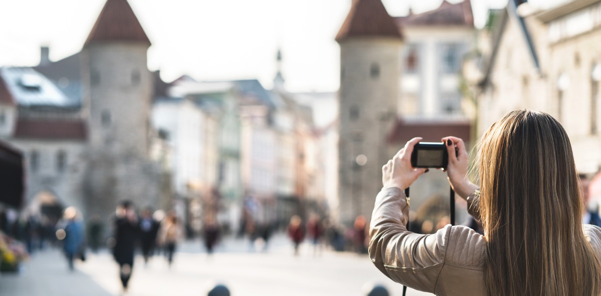 Mujer de espaldas haciendo foto a unas torres antiguas en una plaza