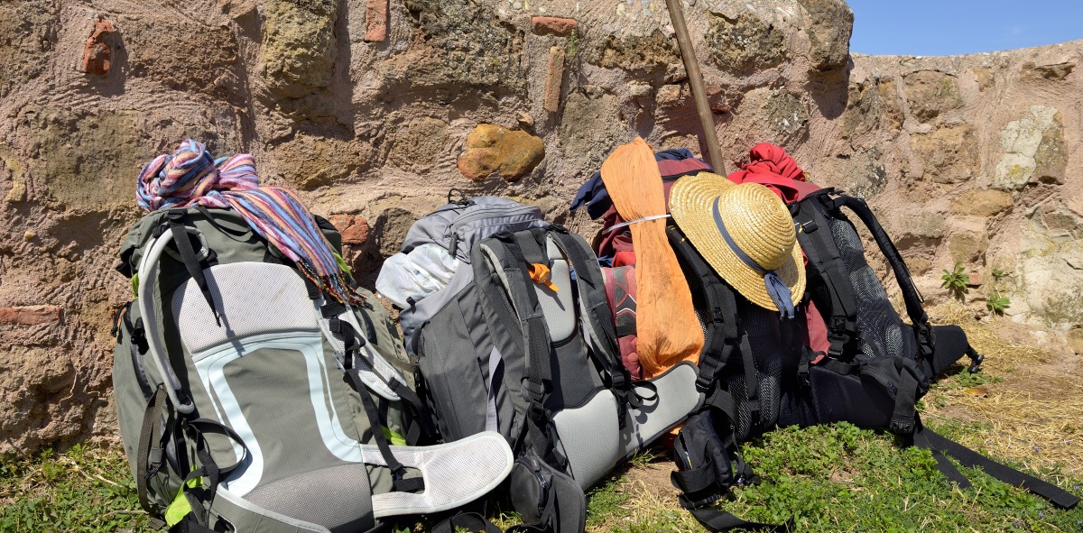 Cuatro mochilas apoyadas en una pared