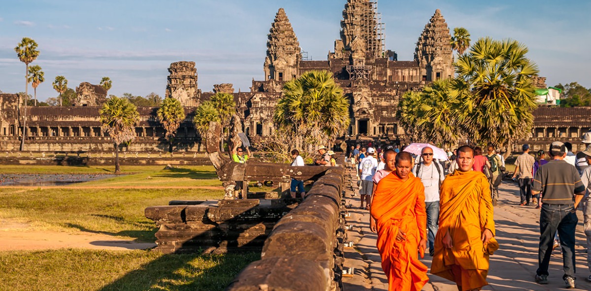 Sacerdotes y turistan saliendo de los Templos de Angkor en Camboya