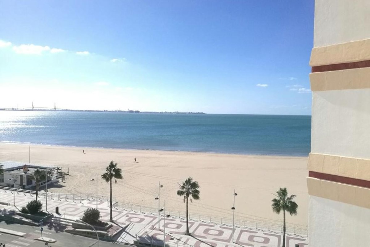 Playa de arena blanca junto al paseo maritimo