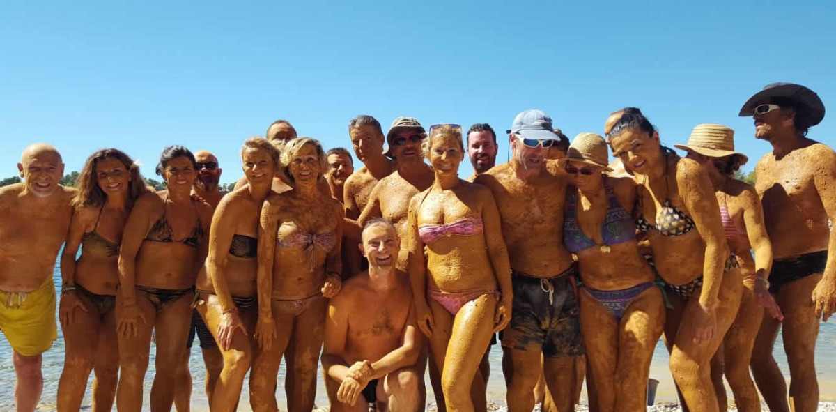 Grupo de Solteros Viajeros en la playa posando sonrientes