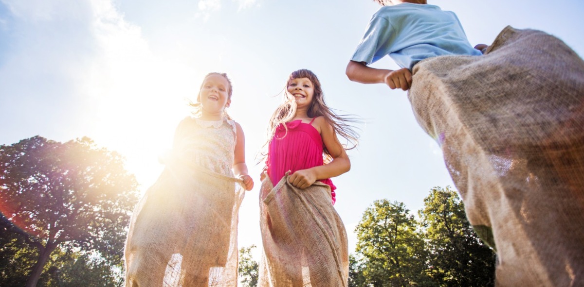 Niños con un saco en las piernas sonriendo