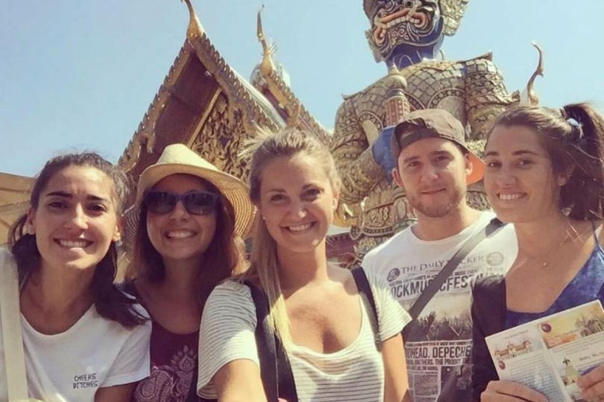 Selfi de grupo de chicas y chicos y detrás la imagen de un demonio