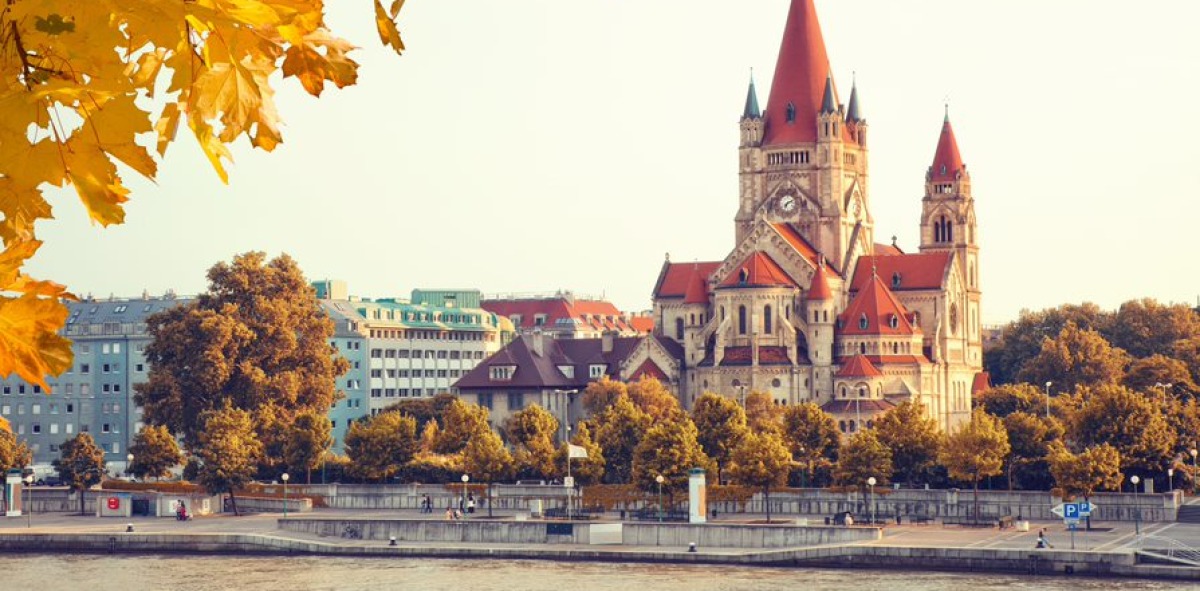 Preciosa iglesia con tejados rojos a orilla del Danubio en viena